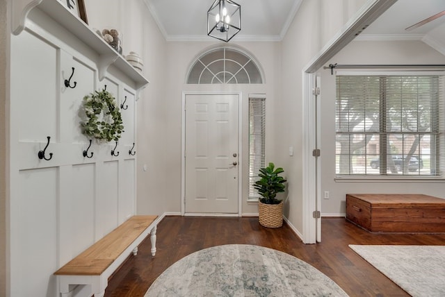 foyer featuring crown molding, baseboards, an inviting chandelier, and dark wood-type flooring