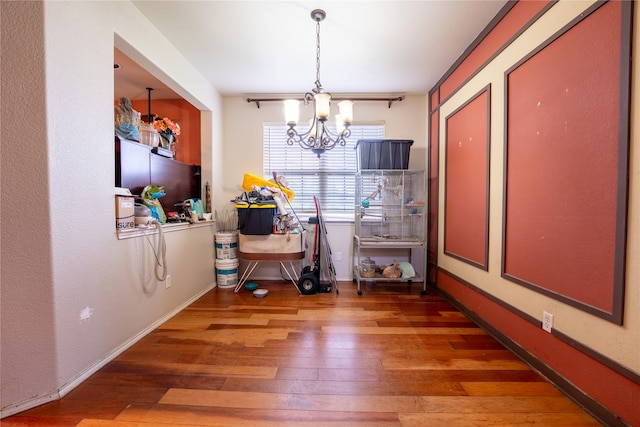 dining room with wood-type flooring, baseboards, and a notable chandelier