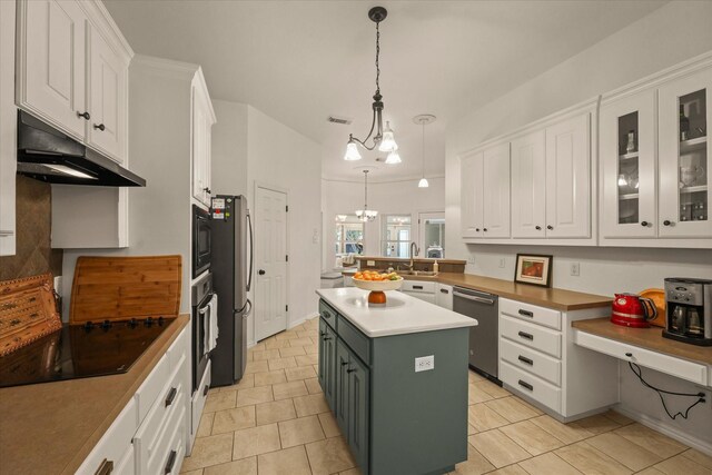 kitchen with hanging light fixtures, white cabinetry, under cabinet range hood, visible vents, and black appliances