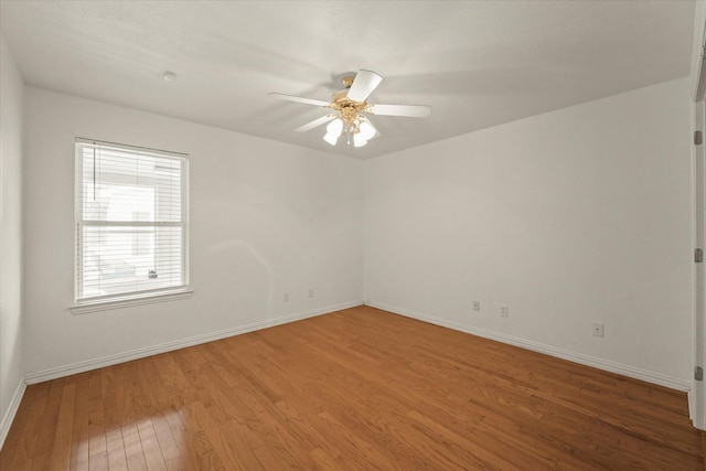 empty room featuring baseboards, ceiling fan, and light wood-style flooring