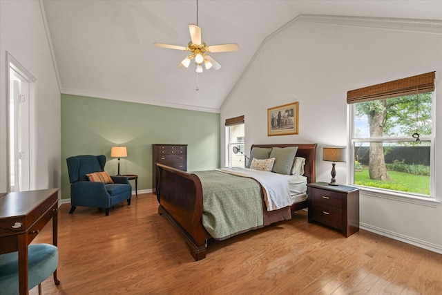 bedroom featuring light wood-style floors, baseboards, multiple windows, and vaulted ceiling