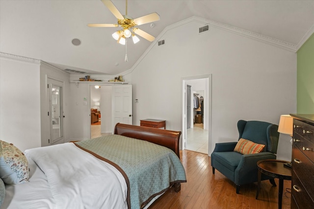 bedroom featuring crown molding, visible vents, wood-type flooring, and vaulted ceiling