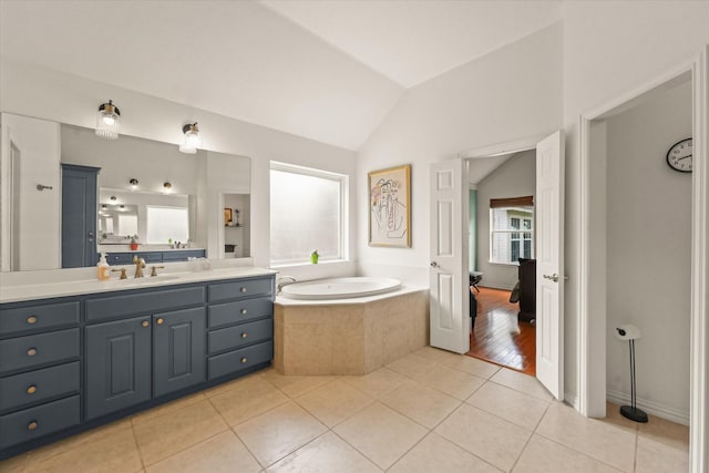 full bathroom with vanity, tile patterned floors, vaulted ceiling, and a garden tub