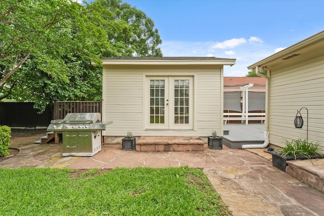 back of property with a patio area, fence, french doors, and a deck