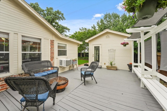 deck with an outdoor living space with a fire pit and an outbuilding