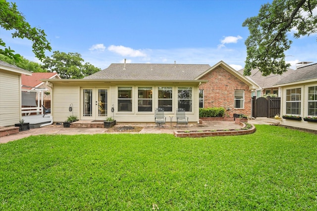 back of house with a lawn, a patio area, french doors, and brick siding