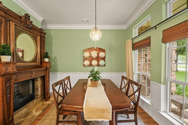 dining area with visible vents, crown molding, wood finished floors, and an inviting chandelier