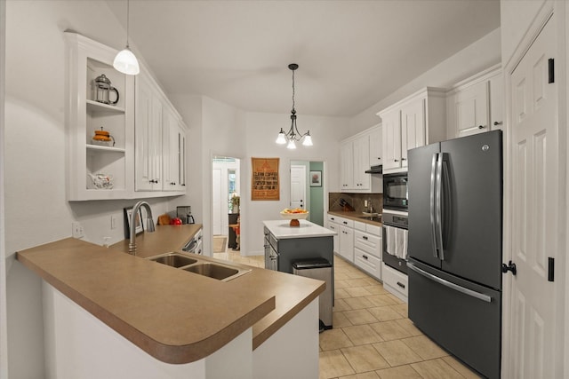 kitchen with a sink, a kitchen island, stainless steel appliances, and white cabinets