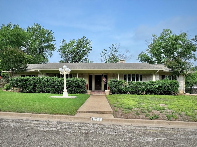 view of front facade featuring brick siding and a front lawn
