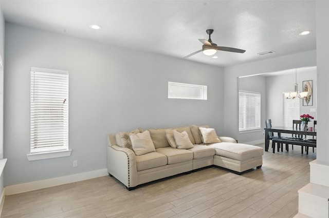 1933 Shaw St, Dallas, TX 75212 - living room with visible vents, light wood-style floors, ceiling fan with notable chandelier, and baseboards