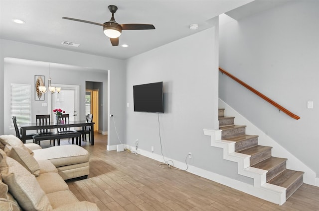 1933 Shaw St, Dallas, TX 75212 - living area with visible vents, baseboards, stairway, light wood-style flooring, and ceiling fan with notable chandelier