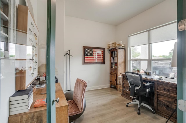 office space featuring baseboards and light wood finished floors
