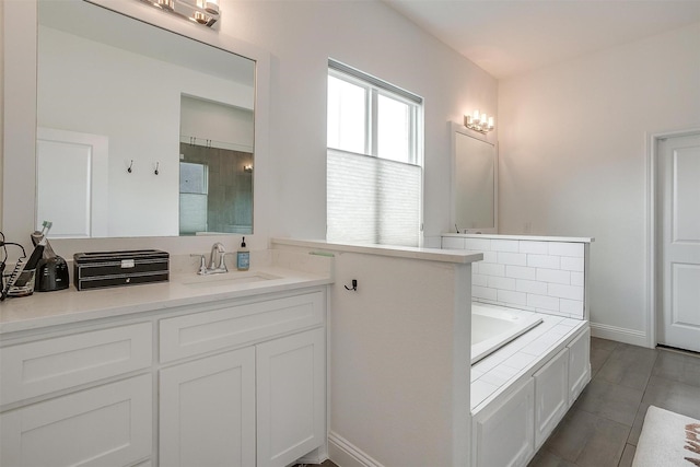 full bath with a tile shower, vanity, tile patterned floors, baseboards, and a garden tub