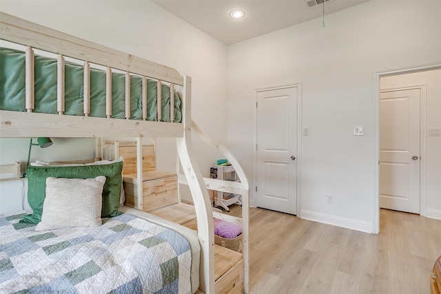 bedroom with baseboards, visible vents, and light wood-style floors