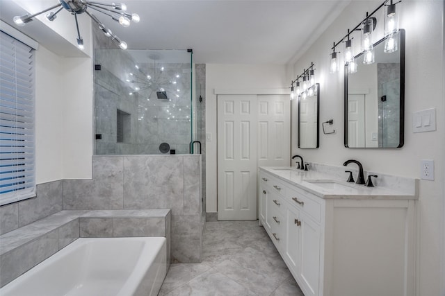 bathroom featuring double vanity, a garden tub, a stall shower, a sink, and a notable chandelier