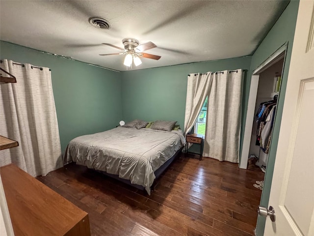 bedroom featuring wood-type flooring, a ceiling fan, a textured ceiling, and visible vents