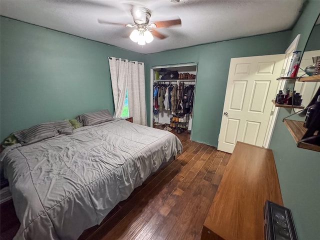 bedroom featuring dark wood-style flooring, ceiling fan, and a closet