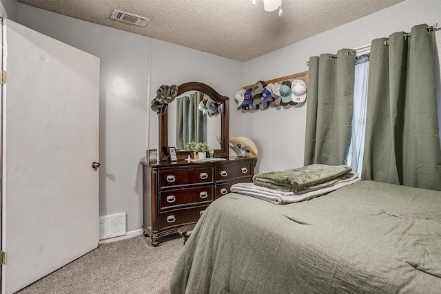 carpeted bedroom with a textured ceiling and visible vents