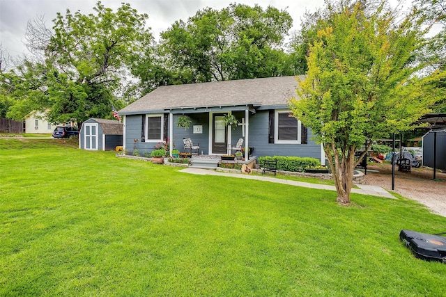 ranch-style home with a storage shed, an outbuilding, a shingled roof, and a front yard