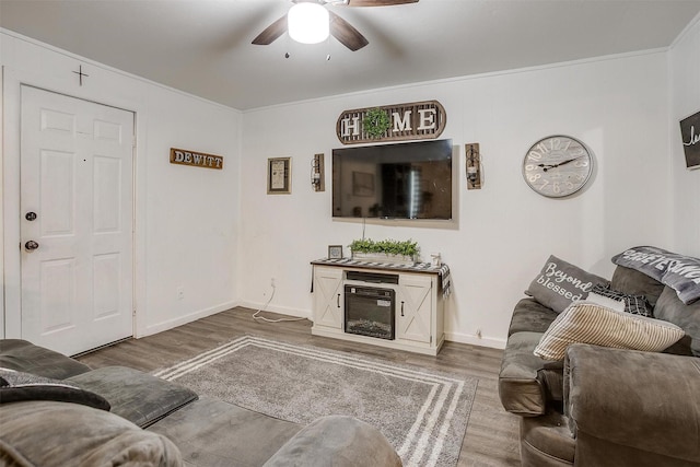 living room featuring baseboards, ceiling fan, and wood finished floors