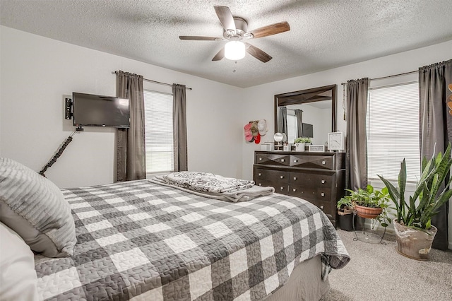 bedroom featuring carpet floors, a ceiling fan, and a textured ceiling