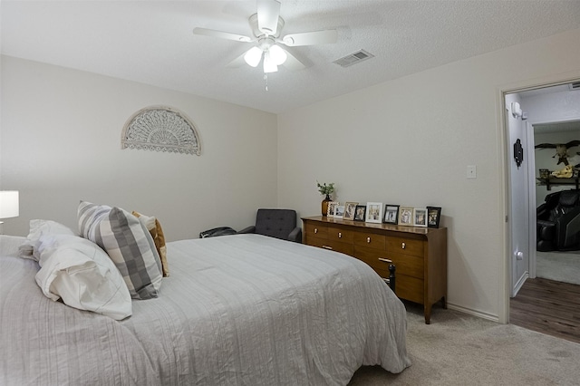 bedroom featuring baseboards, ceiling fan, light colored carpet, and visible vents