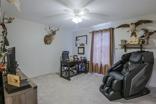 carpeted home office with a ceiling fan and a textured ceiling