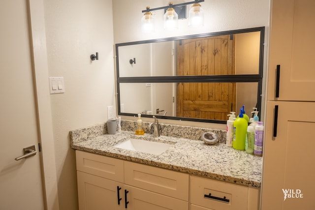 bathroom featuring a textured wall and vanity