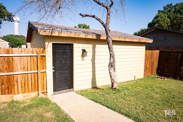 view of outbuilding featuring fence and an outdoor structure