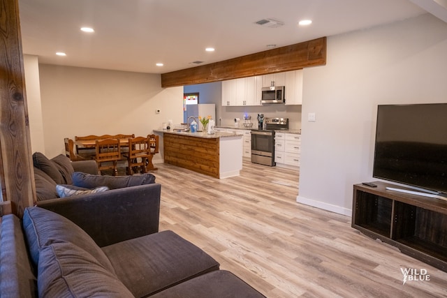 living room featuring baseboards, recessed lighting, light wood-style flooring, and visible vents