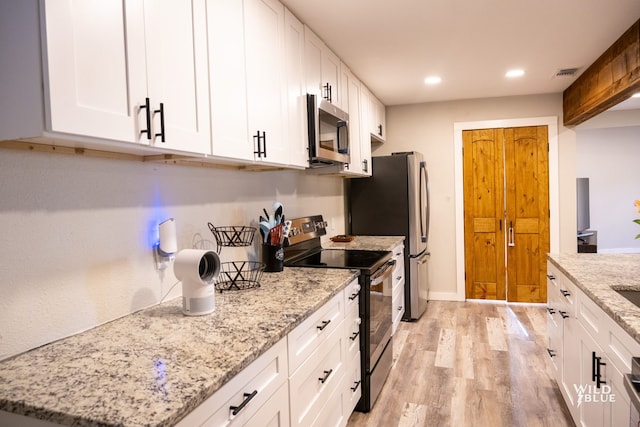 kitchen with appliances with stainless steel finishes, white cabinetry, recessed lighting, light wood-type flooring, and visible vents