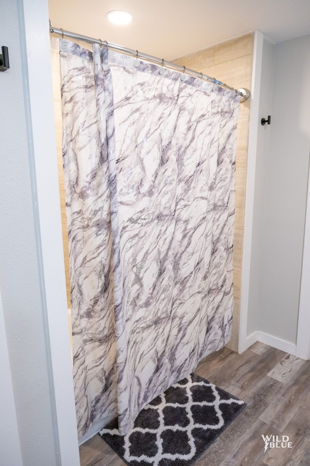 bathroom featuring wood finished floors and curtained shower