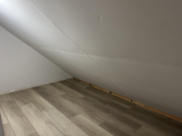 bonus room featuring vaulted ceiling and wood finished floors