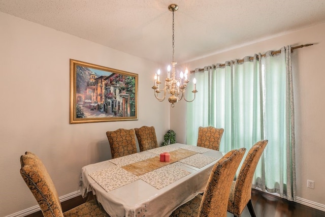 dining room with baseboards, dark wood-type flooring, and a chandelier