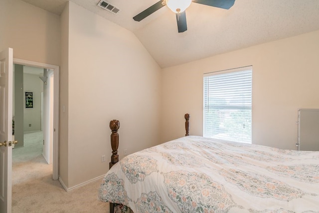 bedroom with visible vents, ceiling fan, lofted ceiling, and light colored carpet