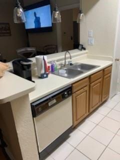 kitchen featuring white dishwasher, hanging light fixtures, a sink, light countertops, and light tile patterned floors