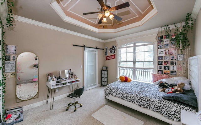 carpeted bedroom with crown molding, baseboards, ceiling fan, a barn door, and a tray ceiling