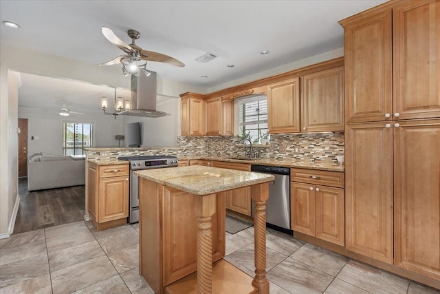 kitchen with island exhaust hood, ceiling fan, a healthy amount of sunlight, and stainless steel appliances
