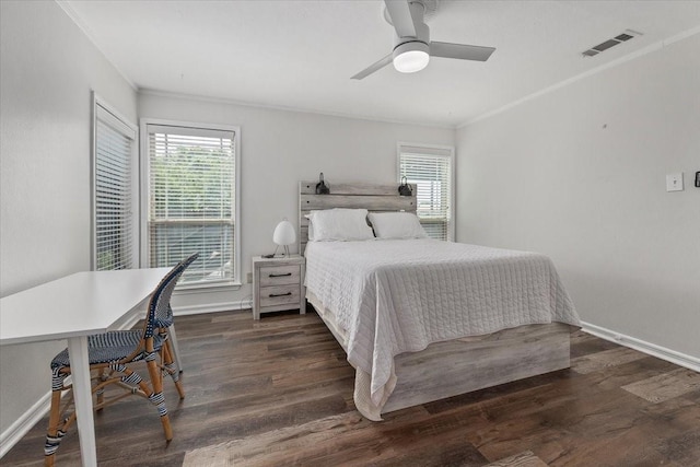bedroom featuring visible vents, baseboards, crown molding, and wood finished floors