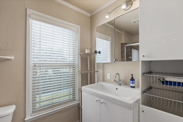 full bathroom featuring crown molding, a wealth of natural light, toilet, and vanity