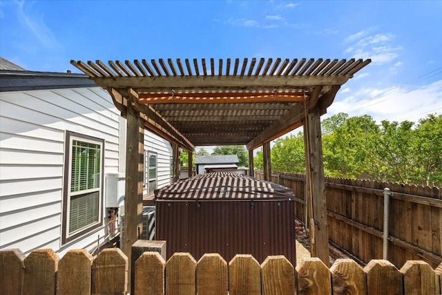 view of patio / terrace with a fenced backyard, a hot tub, and a pergola