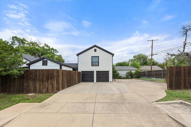 garage featuring fence and driveway