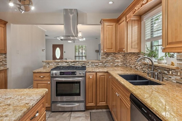 kitchen with backsplash, island exhaust hood, a sink, light stone counters, and stainless steel appliances