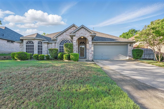 view of front of property with driveway, brick siding, fence, a front lawn, and an attached garage