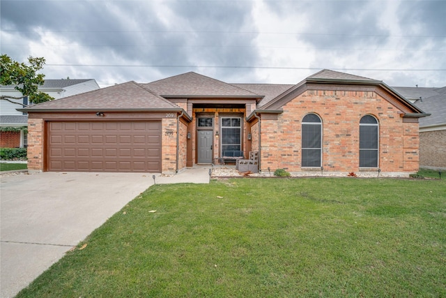 single story home featuring a garage, a front lawn, roof with shingles, brick siding, and driveway
