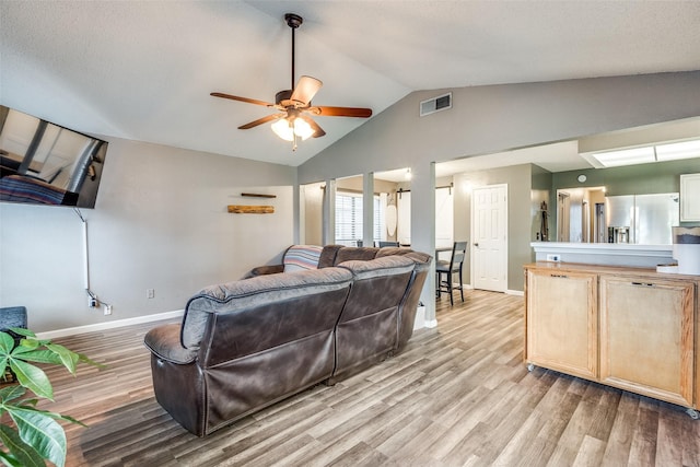 living room featuring visible vents, light wood-style floors, ceiling fan, and baseboards