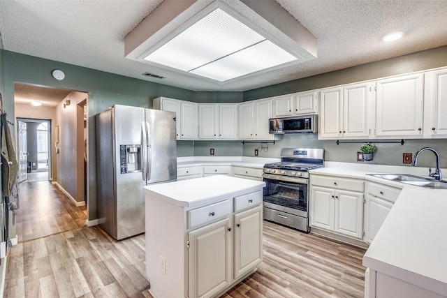 kitchen featuring a sink, stainless steel appliances, light wood-type flooring, and visible vents