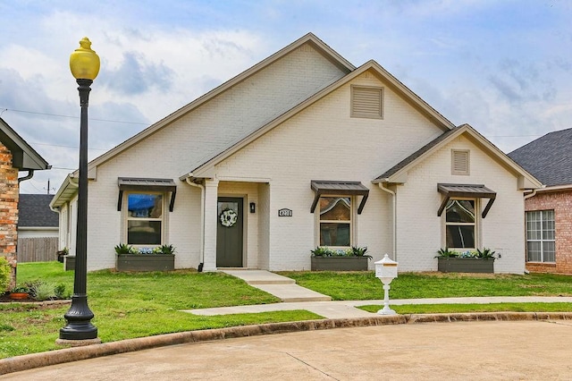 view of front of home featuring brick siding and a front lawn