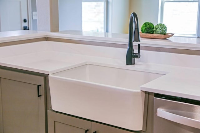 room details featuring a sink, light countertops, and stainless steel dishwasher