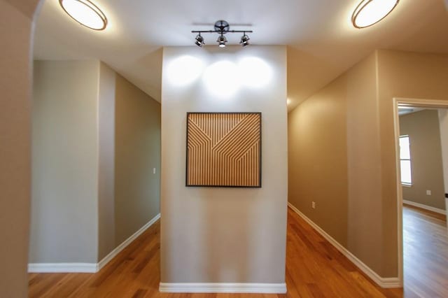 hallway featuring baseboards and wood finished floors